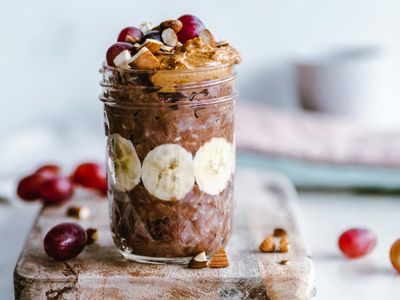Frasco de vidrio con avena nocturna en capas, rodajas de banano y crema de maní