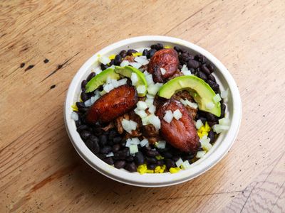 Bowl de arroz con fréjol negro, maduro asado, aguacate y cebolla picada