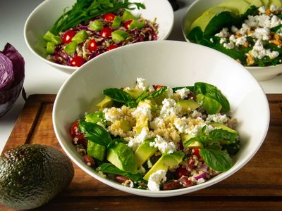 Bowls de ensalada de quinua con aguacate, queso fresco y hojas verdes