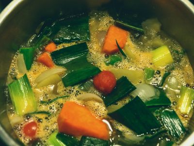 Olla de sopa de verduras con zanahoria, puerro y tomate